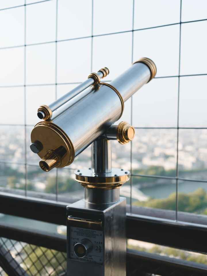 vintage metal made telescope on tower